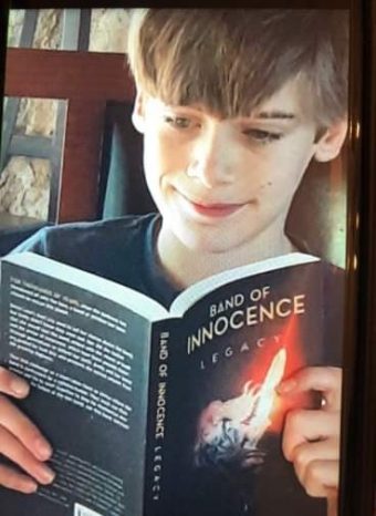 11-year-old boy reading Band of Innocence - Legacy book